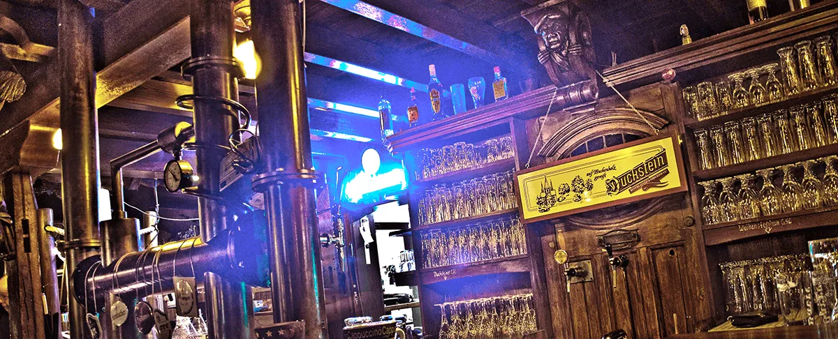 Die Bar mit blauem Neonlicht und Gläserreihen über dem Tresen