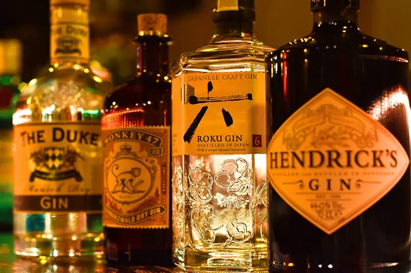 Mehrere Gin-Flaschen im warmen Licht der Bar