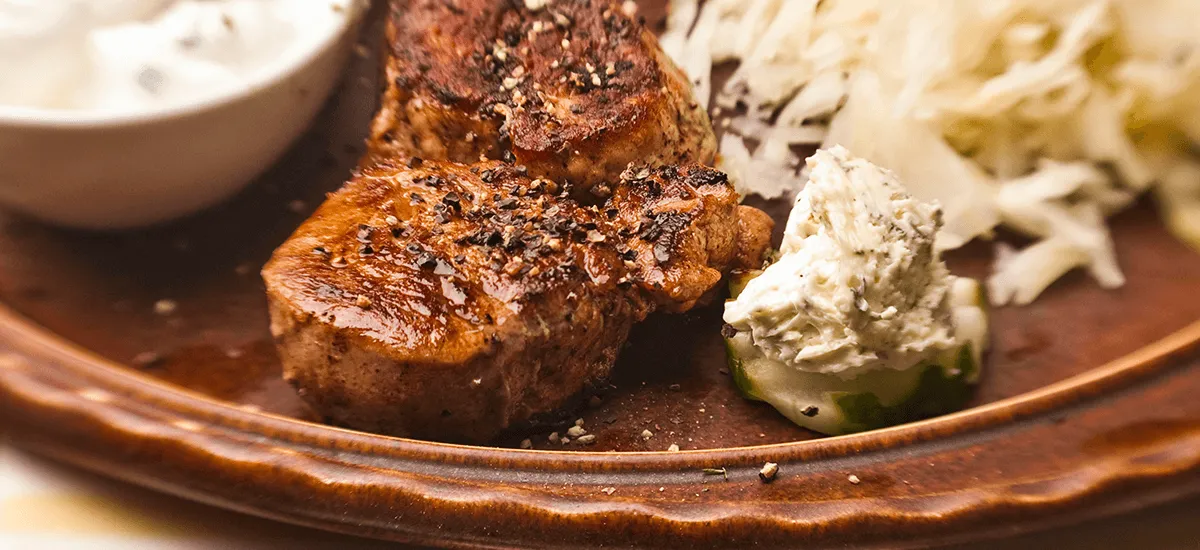 Gebratenes Steak mit Kräuterbutter auf einem Tonteller